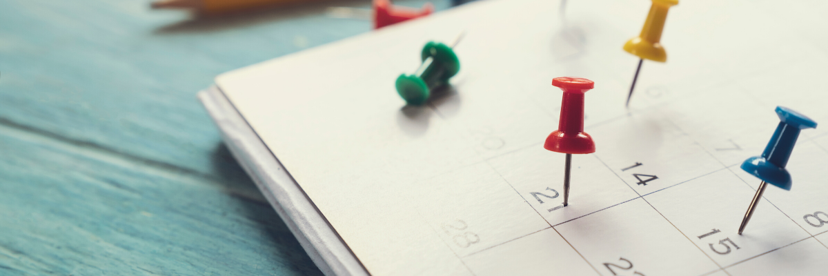 Thumbtacks pinned onto different calendar dates