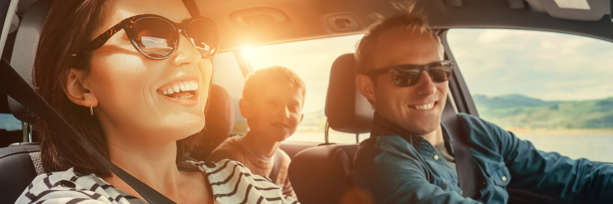 Family riding in car and smiling